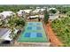 Aerial view of neighborhood tennis courts, lush landscaping, and parking at 6610 Gasparilla Pines Blvd # 111, Englewood, FL 34224