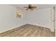 Bright bedroom featuring wood-look floors, a ceiling fan, and a sunny window with blinds at 6610 Gasparilla Pines Blvd # 111, Englewood, FL 34224
