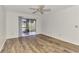 Bedroom featuring white walls, wood-look floors, and sliding glass doors to screened porch at 6610 Gasparilla Pines Blvd # 111, Englewood, FL 34224