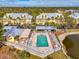 Aerial view of community pool with lounge area, picnic tables, and lush landscaping, perfect for outdoor enjoyment at 6610 Gasparilla Pines Blvd # 111, Englewood, FL 34224
