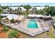 Aerial view of community pool with lounge area and dining perfect for socializing, surrounded by attractive landscaping at 6610 Gasparilla Pines Blvd # 111, Englewood, FL 34224