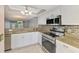Bright kitchen features white cabinetry, granite countertops, stainless steel appliances and decorative backsplash at 6610 Gasparilla Pines Blvd # 111, Englewood, FL 34224