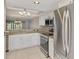 Kitchen boasts stainless steel appliances, granite counters, and white cabinetry at 6610 Gasparilla Pines Blvd # 111, Englewood, FL 34224