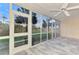 Screened lanai features tile floor and peaceful outdoor view with access door at 6610 Gasparilla Pines Blvd # 111, Englewood, FL 34224