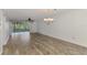 Bright living room with wood-look floors and sliding glass doors leading to a screened lanai at 6610 Gasparilla Pines Blvd # 111, Englewood, FL 34224