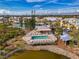 Aerial view of the community pool, cabana, and a scenic pond with lush tropical landscaping at 6610 Gasparilla Pines Blvd # 111, Englewood, FL 34224