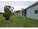Green backyard featuring a large lawn, a screened patio, and mature trees at 6998 Dabarsky Ave, North Port, FL 34291