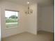 Formal dining room features elegant chandelier, natural light, and neutral paint at 6998 Dabarsky Ave, North Port, FL 34291