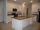 Open-concept kitchen with an island, granite countertops, and modern stainless steel appliances at 6998 Dabarsky Ave, North Port, FL 34291