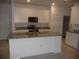 Open concept kitchen with granite countertops, a center island, and modern appliances at 6998 Dabarsky Ave, North Port, FL 34291