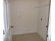 Tile laundry room with storage rack and door at 6998 Dabarsky Ave, North Port, FL 34291