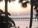 Beautiful sunset over the water with a pier, framed by palm trees at 6998 Dabarsky Ave, North Port, FL 34291