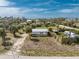 Birds eye view of the home and neighborhood showcasing tropical trees, a gravel driveway, and fencing at 7032 Duke St, Englewood, FL 34224
