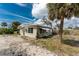 Exterior view of home with white trim, palms and gravel driveway at 7032 Duke St, Englewood, FL 34224