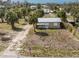 Charming home featuring a metal roof and a spacious, partially landscaped yard with mature palm trees at 7032 Duke St, Englewood, FL 34224