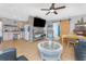 Open-concept living room with a stone-accent wall, wood floors, and cozy furnishings at 7032 Duke St, Englewood, FL 34224
