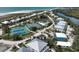 Aerial view of a charming neighborhood showcasing tennis courts, pool, diverse housing and coastal waterway at 7237 Rum Bay Dr # 5022, Placida, FL 33946