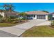 Inviting single-story home with a long driveway, manicured lawn, and mature palm trees enhancing the curb appeal at 7305 Innsbrook St, Englewood, FL 34224