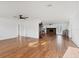 Open-concept living space with hardwood floors, a modern ceiling fan, and a stone fireplace creating a warm ambiance at 7305 Innsbrook St, Englewood, FL 34224