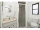 Bright bathroom featuring a vanity with a sink, a shower with a glass door, and a toilet at 8159 Archie St, Englewood, FL 34224