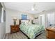 Cozy bedroom with tropical themed bedding, wood furniture, and a ceiling fan at 8159 Archie St, Englewood, FL 34224