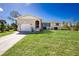 Inviting single-story home boasts a lush front yard and an attached garage at 8159 Archie St, Englewood, FL 34224