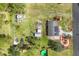 Aerial view of a property with solar panels, garden areas, fenced-in backyard and accessory storage buildings at 840 E 7Th St, Englewood, FL 34223