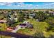 Expansive aerial view of property showing the home's layout, fenced yard, outbuildings and mature trees on a sunny day at 840 E 7Th St, Englewood, FL 34223