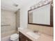 Bathroom with a tiled walk-in shower, granite vanity countertop, and brown cabinets at 840 E 7Th St, Englewood, FL 34223
