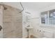 Bright bathroom features a tiled shower, pedestal sink, and a window for natural light at 840 E 7Th St, Englewood, FL 34223