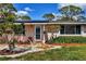 Inviting front door with stone pathway surrounded by colorful flowers and lush greenery at 840 E 7Th St, Englewood, FL 34223