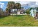 Fenced backyard with grassy lawn, palm trees, and utility shed, perfect for outdoor activities at 849 Palmetto St, Englewood, FL 34223