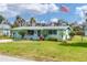 Charming single-story home featuring a well-maintained lawn, mature landscaping, and an American flag at 849 Palmetto St, Englewood, FL 34223