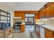 Functional kitchen with wood cabinets, and modern stainless steel appliances, seamlessly flowing into the living area at 849 Palmetto St, Englewood, FL 34223