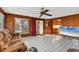 The inviting living room features wood walls, bright tile floors, and sliding glass doors to the back patio at 849 Palmetto St, Englewood, FL 34223
