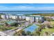 Aerial view featuring community buildings, a tennis court, lush landscaping and tranquil water views at 9203 Griggs Rd # 204, Englewood, FL 34224