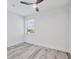 A bedroom with hardwood floors, window overlooking neighborhood, and modern ceiling fan at 9203 Griggs Rd # 204, Englewood, FL 34224