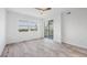 Bright bedroom with light wood floors, big windows, and a sliding glass door to a balcony with scenic views at 9203 Griggs Rd # 204, Englewood, FL 34224