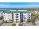 Stunning building exterior with a green roof, balconies, and lush landscaping overlooking the water at 9203 Griggs Rd # 204, Englewood, FL 34224