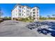 Scenic building exterior with balconies and a parking lot surrounded by manicured landscaping at 9203 Griggs Rd # 204, Englewood, FL 34224