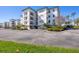 Elegant building exterior featuring balconies, beautiful landscaping, and ample parking spaces at 9203 Griggs Rd # 204, Englewood, FL 34224