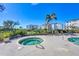 Inviting hot tub with lounge chairs, landscaping, and building view for resort-style relaxation at 9203 Griggs Rd # 204, Englewood, FL 34224