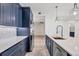 Modern kitchen featuring blue cabinetry, stainless steel appliances, a large island, and white countertops at 9203 Griggs Rd # 204, Englewood, FL 34224