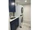 A laundry room with a large stacked washer and dryer and a sink at 9203 Griggs Rd # 204, Englewood, FL 34224