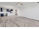 Open-concept living space featuring light wood floors and a view of the modern kitchen and its stainless steel appliances at 9203 Griggs Rd # 204, Englewood, FL 34224