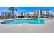 Inviting community pool with surrounding lounge chairs and lush landscaping at 9203 Griggs Rd # 204, Englewood, FL 34224
