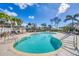 Sparkling community pool with surrounding lounge chairs, umbrellas, and landscaping at 9203 Griggs Rd # 204, Englewood, FL 34224