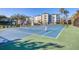 Outdoor tennis court with net for friendly matches, surrounded by lush greenery, perfect for active residents at 9203 Griggs Rd # 204, Englewood, FL 34224