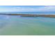 Wide aerial of bay with distant islands and a boat leaving a foamy trail at 9203 Griggs Rd # A204, Englewood, FL 34224
