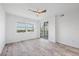 Modern bedroom with wood-look floors, white walls, and sliding glass doors leading to the balcony at 9203 Griggs Rd # A204, Englewood, FL 34224